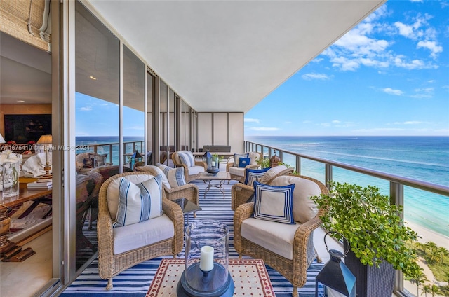 balcony featuring an outdoor living space, a view of the beach, and a water view