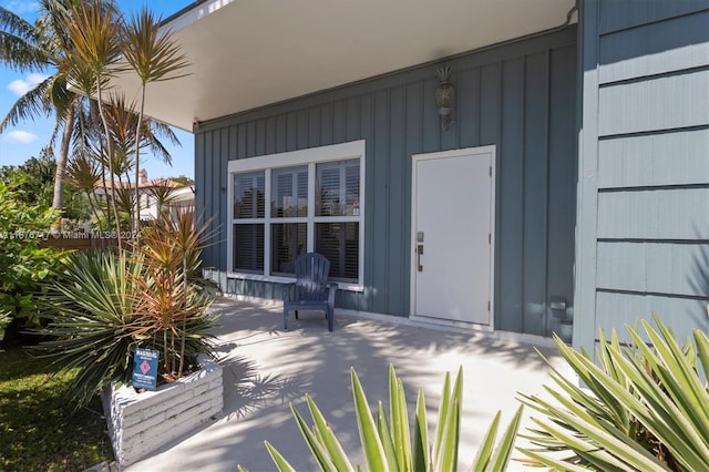 view of exterior entry with a patio area