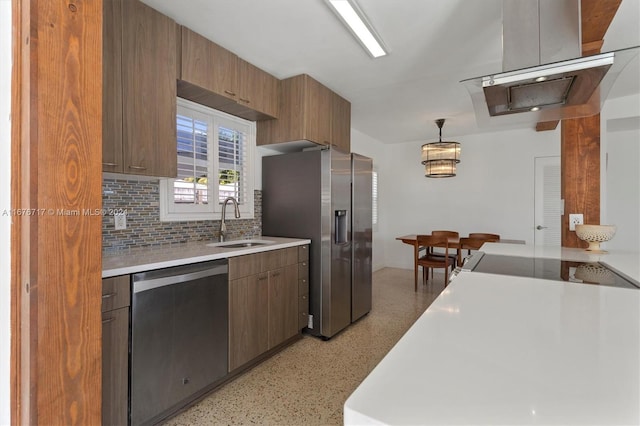 kitchen with appliances with stainless steel finishes, backsplash, pendant lighting, and sink