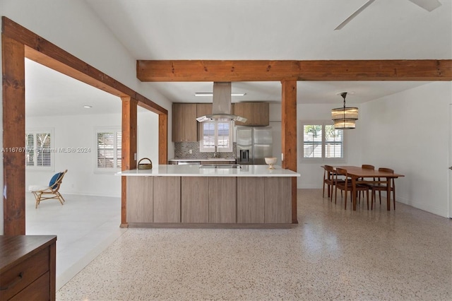 kitchen featuring tasteful backsplash, stainless steel fridge with ice dispenser, island exhaust hood, kitchen peninsula, and pendant lighting