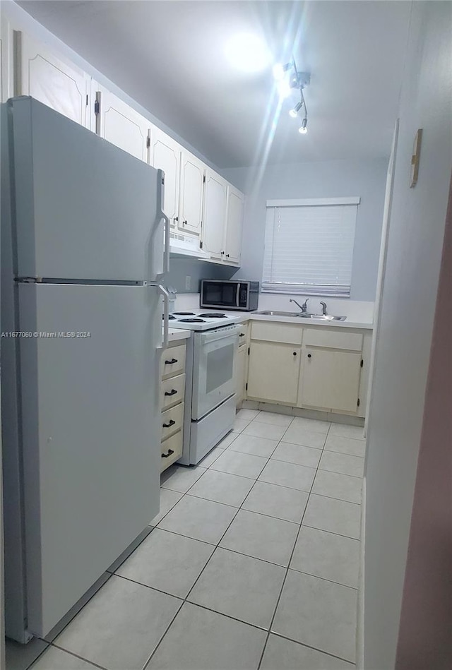 kitchen with sink, white cabinets, white appliances, and light tile patterned floors