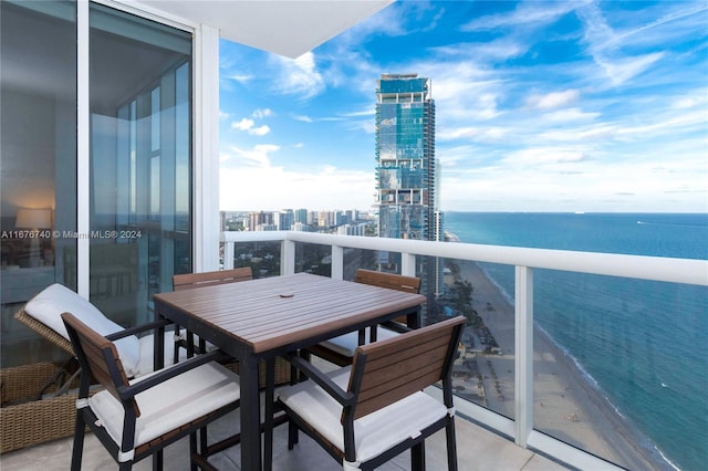 balcony with a water view and a view of the beach