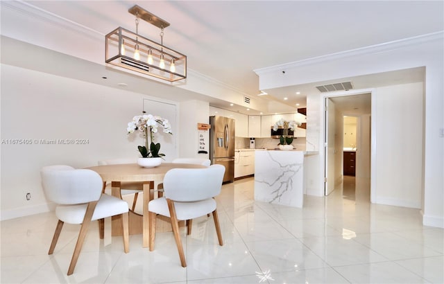 dining area featuring ornamental molding and light tile patterned floors