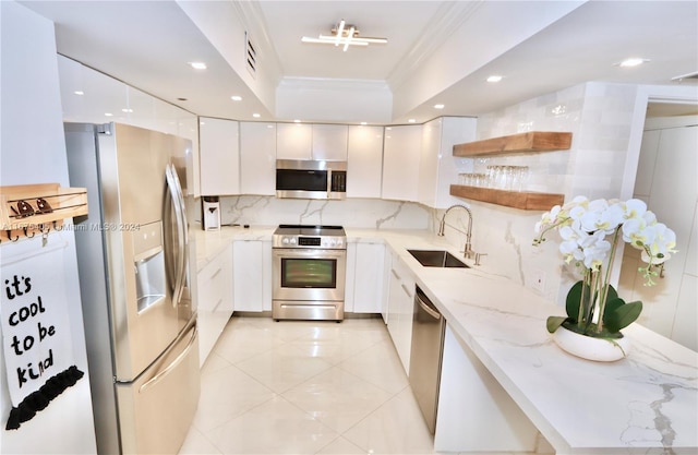 kitchen with white cabinetry, crown molding, appliances with stainless steel finishes, and sink