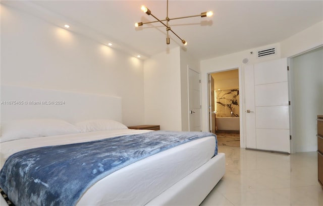 bedroom with ensuite bathroom and an inviting chandelier