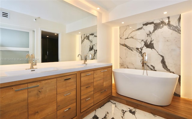 bathroom featuring vanity, a tub, and tile walls