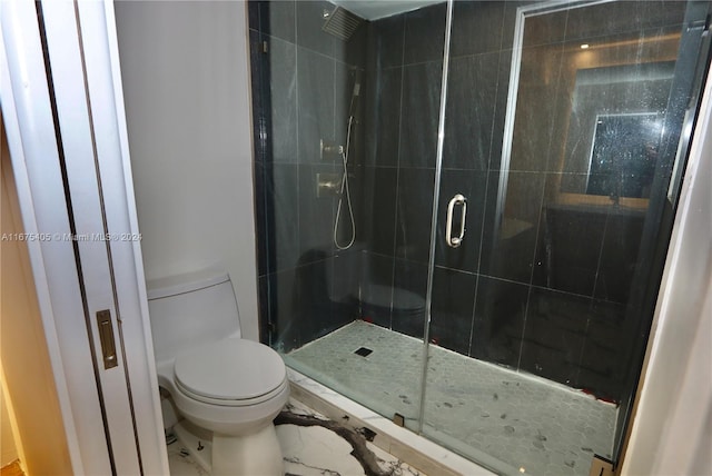 bathroom with toilet and a shower with shower door