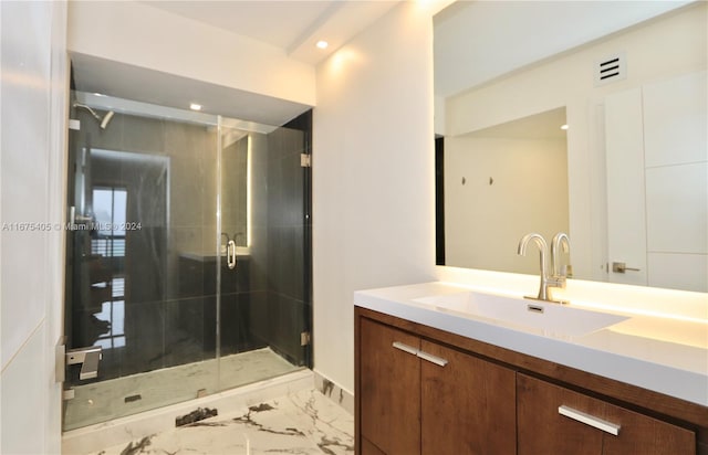 bathroom with vanity and a shower with shower door