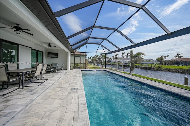 view of pool with glass enclosure, ceiling fan, and a patio area