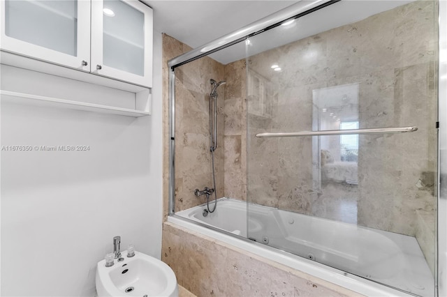 bathroom featuring a bidet and bath / shower combo with glass door