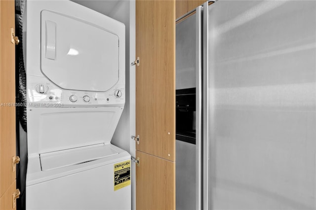 clothes washing area featuring stacked washer / dryer