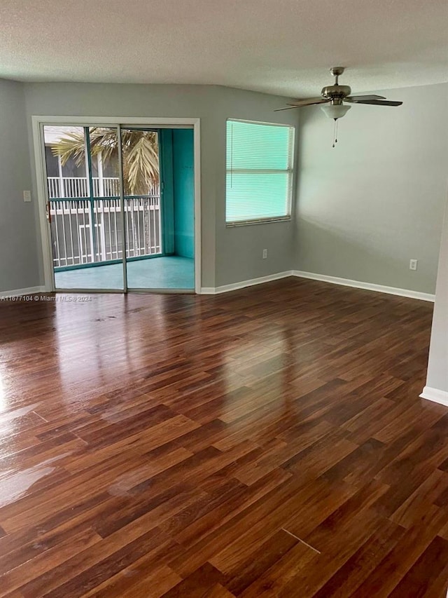 unfurnished living room featuring a textured ceiling, plenty of natural light, and dark hardwood / wood-style flooring