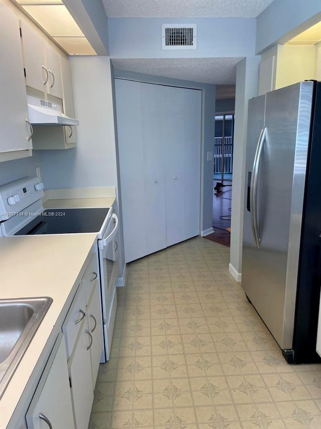 kitchen featuring range with electric stovetop, white cabinets, stainless steel refrigerator with ice dispenser, and a textured ceiling