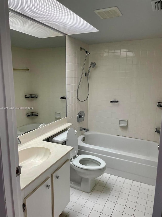 full bathroom with vanity, toilet, tile patterned floors, and tiled shower / bath combo