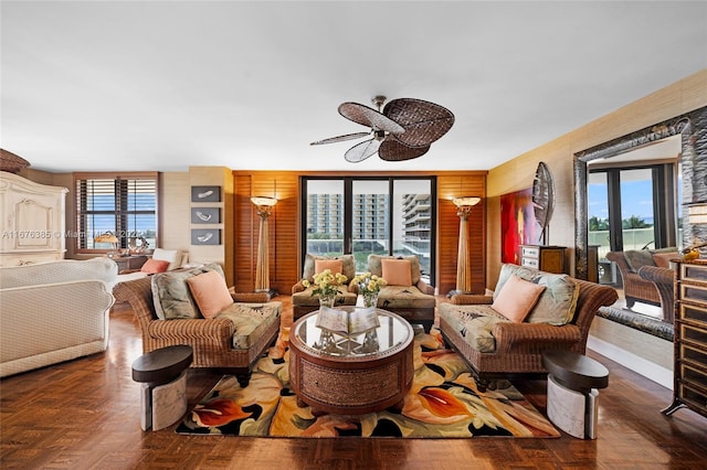 living room with plenty of natural light, ceiling fan, and dark parquet flooring