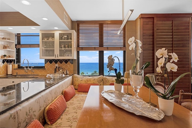 kitchen with a water view, tasteful backsplash, and sink