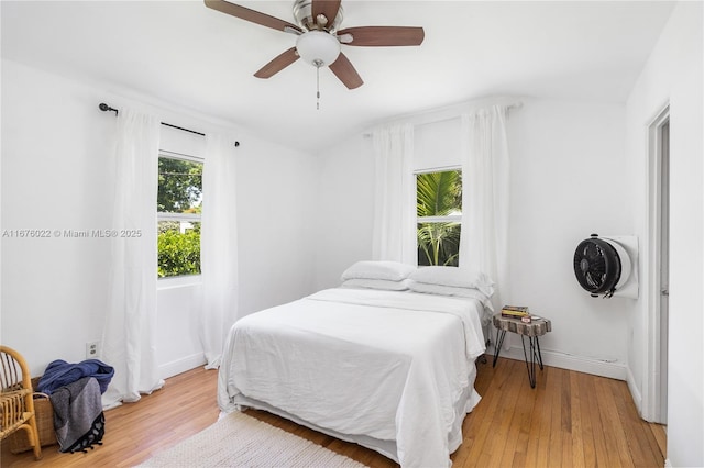 bedroom featuring light wood-type flooring, baseboards, and a ceiling fan