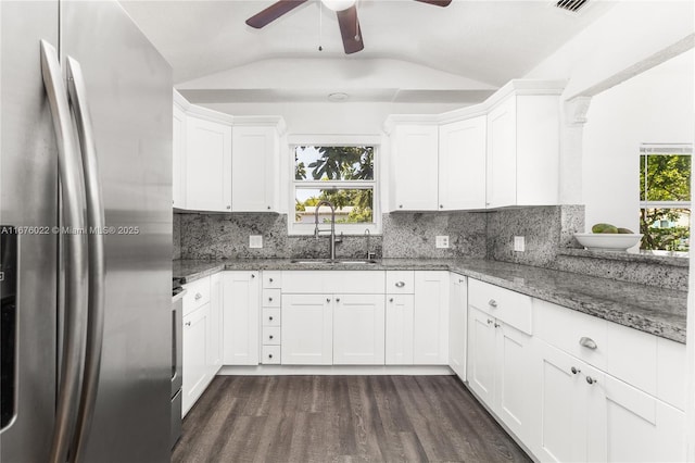 kitchen with tasteful backsplash, lofted ceiling, dark wood-style flooring, freestanding refrigerator, and a sink