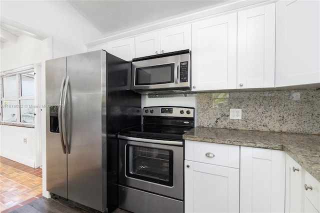 kitchen with stainless steel appliances, white cabinets, and backsplash