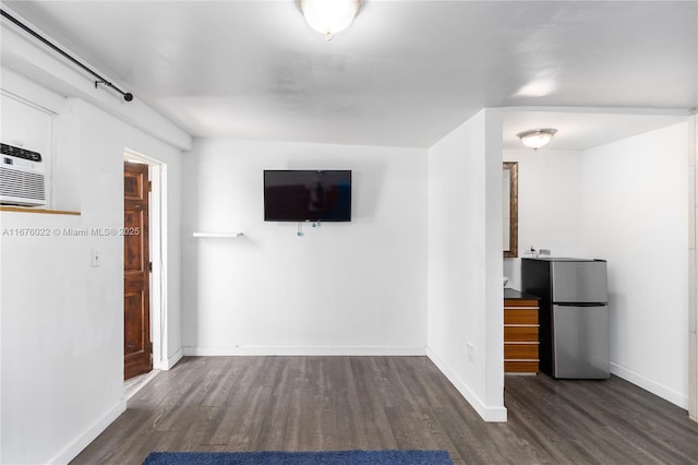 unfurnished living room featuring wood finished floors and baseboards