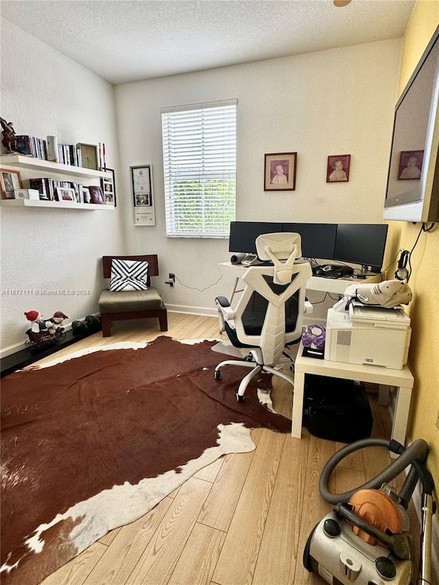 home office featuring a textured ceiling and light hardwood / wood-style flooring