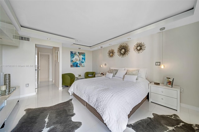 bedroom featuring light tile patterned flooring and a raised ceiling