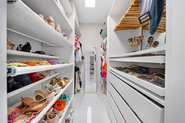 walk in closet with light tile patterned floors