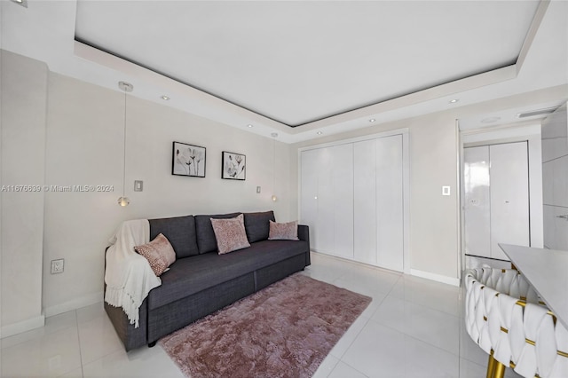 living room featuring light tile patterned flooring and a tray ceiling