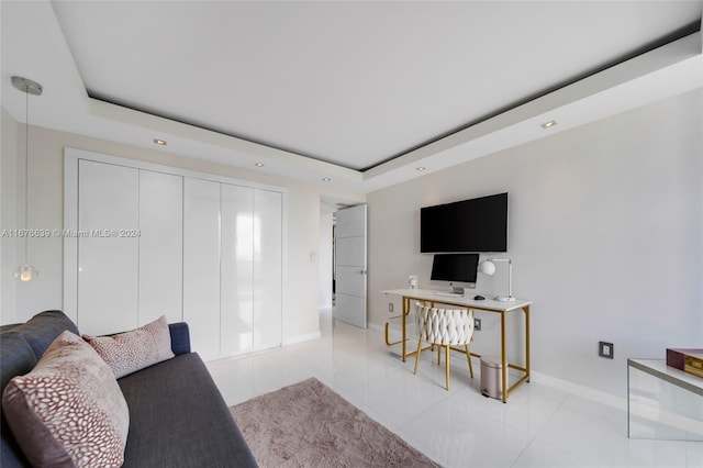 living room with light tile patterned flooring and a raised ceiling