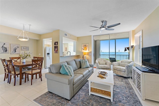 tiled living room with sink and ceiling fan