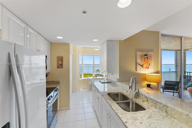 kitchen featuring sink, electric range, white refrigerator, white cabinets, and a water view