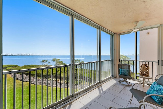 unfurnished sunroom with a water view and ceiling fan