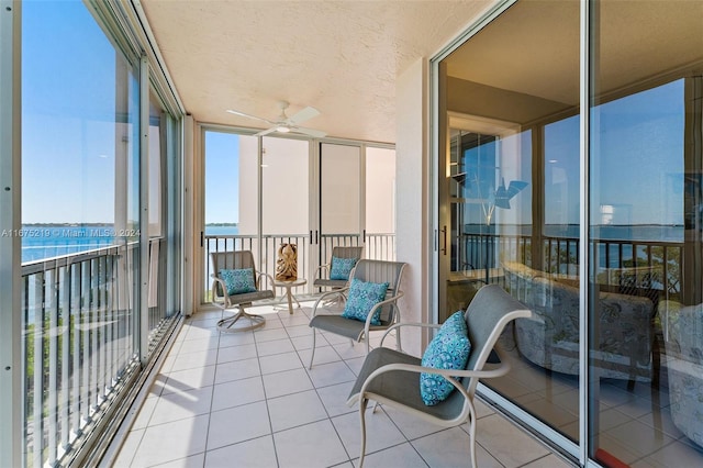 balcony featuring a water view and ceiling fan