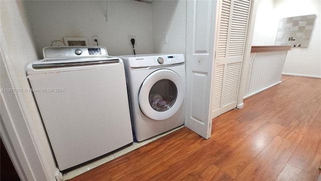 clothes washing area with light hardwood / wood-style flooring and separate washer and dryer