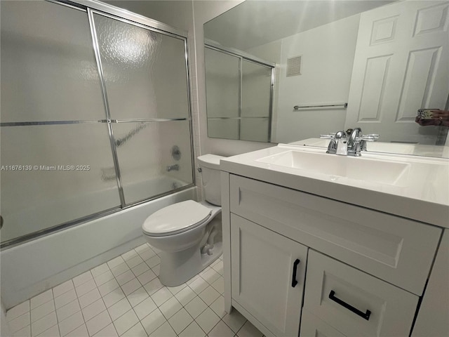 full bathroom with tile patterned floors, vanity, bath / shower combo with glass door, and toilet