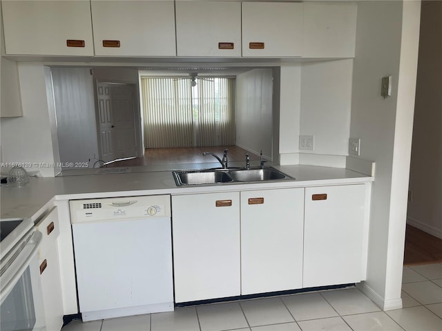 kitchen with white cabinets, dishwasher, light tile patterned flooring, and sink