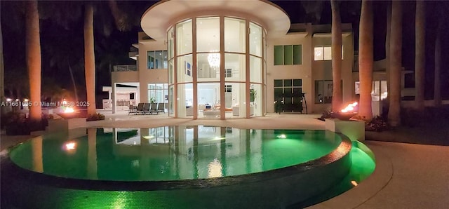 pool at twilight featuring a patio