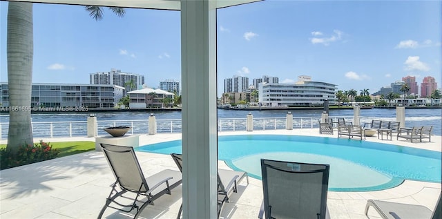 view of swimming pool featuring a patio area and a water view