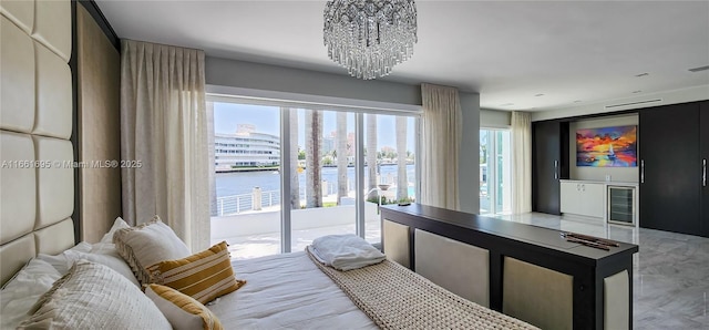 bedroom featuring a chandelier, a water view, beverage cooler, and access to outside