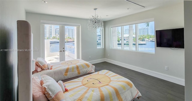 bedroom featuring access to outside, french doors, dark hardwood / wood-style flooring, and a chandelier