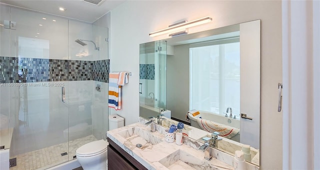 bathroom featuring toilet, vanity, and walk in shower