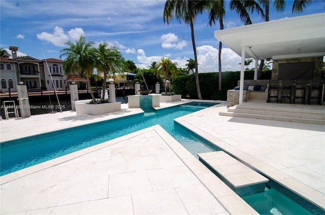 view of swimming pool with a patio area, an in ground hot tub, and a bar