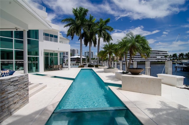 view of pool featuring a patio area and a water view