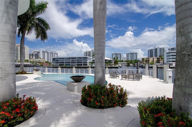 view of swimming pool with a patio area and a water view