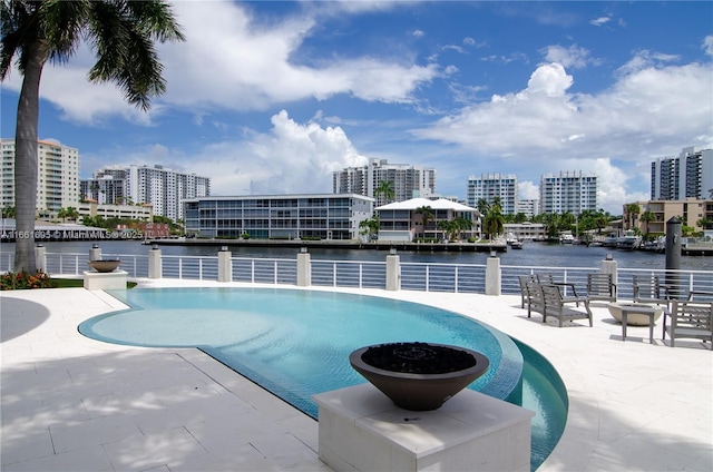 view of pool with a water view and a patio