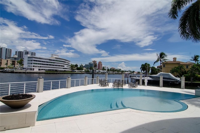 view of swimming pool with a water view and a patio