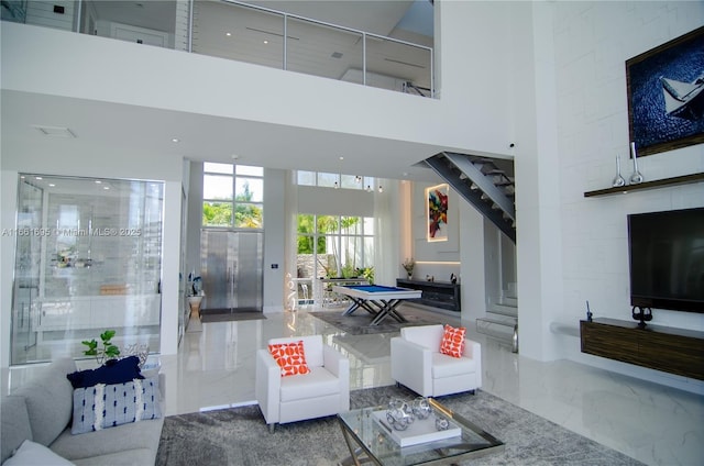 living room featuring billiards and a high ceiling