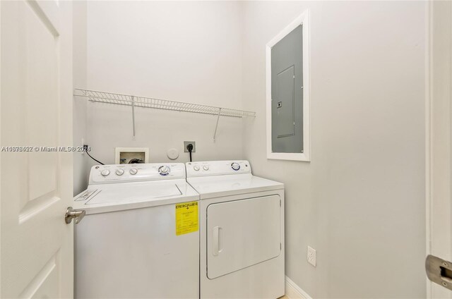 washroom featuring electric panel and washer and clothes dryer