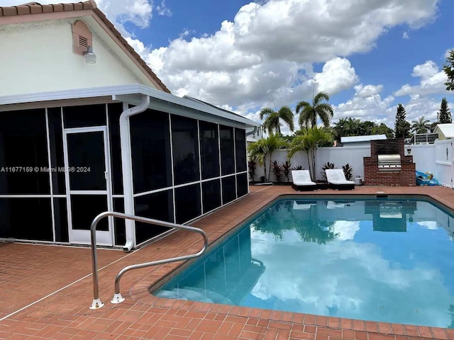 view of swimming pool featuring a patio and a sunroom