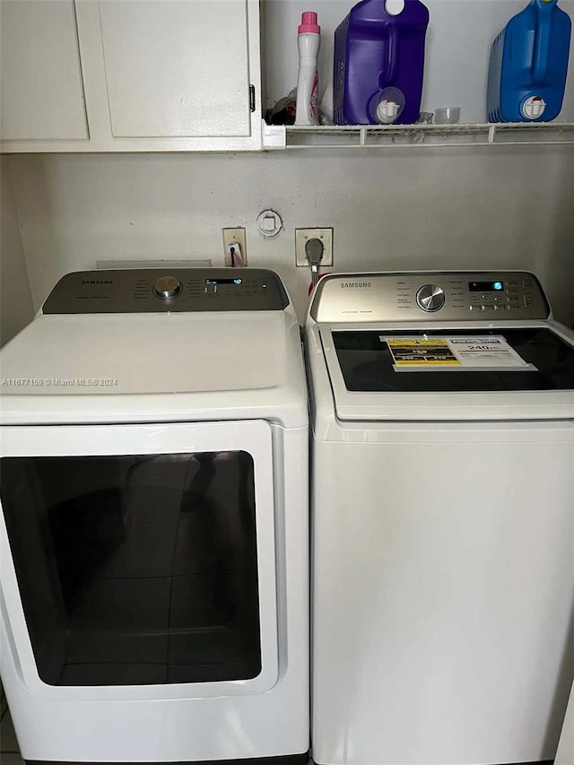 laundry area featuring washing machine and dryer and cabinets